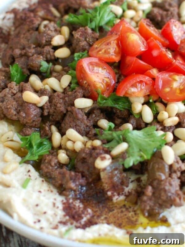 Lebanese Beef Kafta Meatballs with Garlic-Yogurt Sauce 6 Hummus with Spiced Beef and Toasted Pine Nuts on white plate