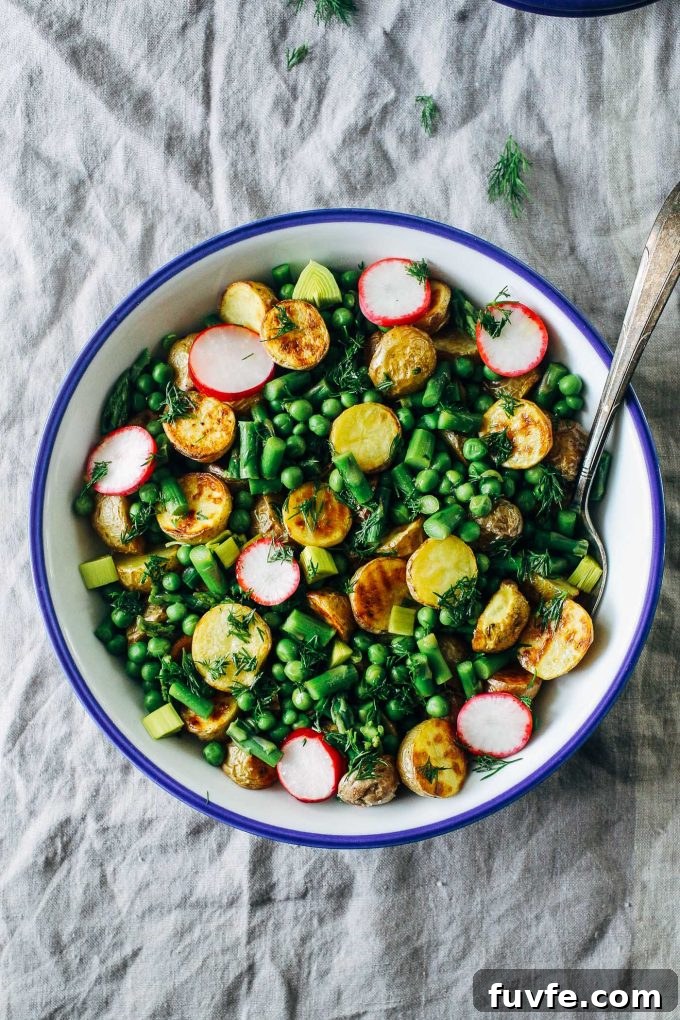 Spring potato salad in a bowl with a serving spoon