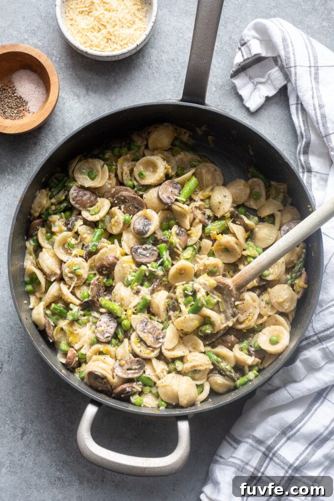 One pot pasta primavera with spring vegetables in skillet.