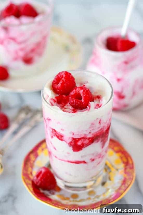 A glass of rhubarb fool, topped with fresh raspberries.