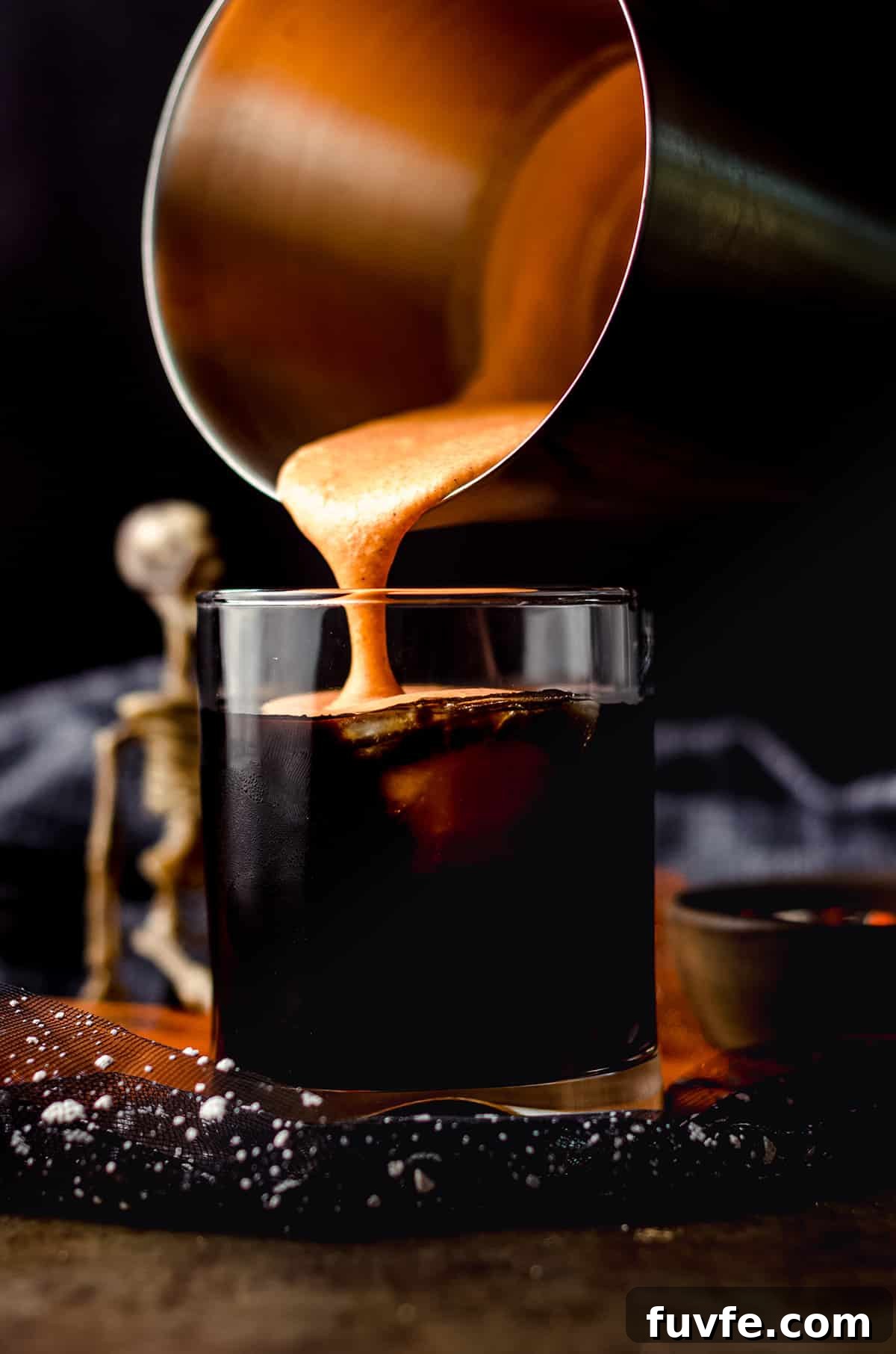 Iced Witches’ Brew Coffee: Spiced Cold Brew Recipe for Fall 8 pouring pumpkin spice cold foam onto a cup of disney copycat cold witches brew coffee