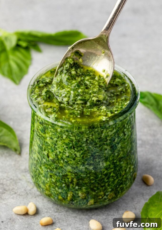 Basil pesto in a jar with spoon digging in