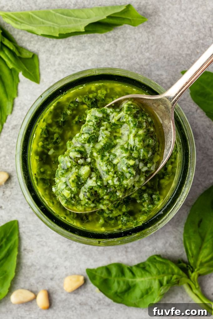 Spoonful of basil pesto sauce over a jar