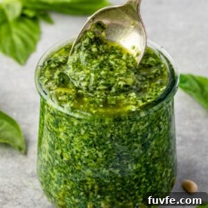 Basil pesto in a jar with spoon digging in