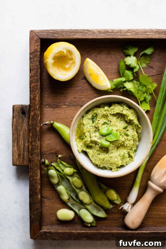 Fava bean dip in a white bowl on a serving board