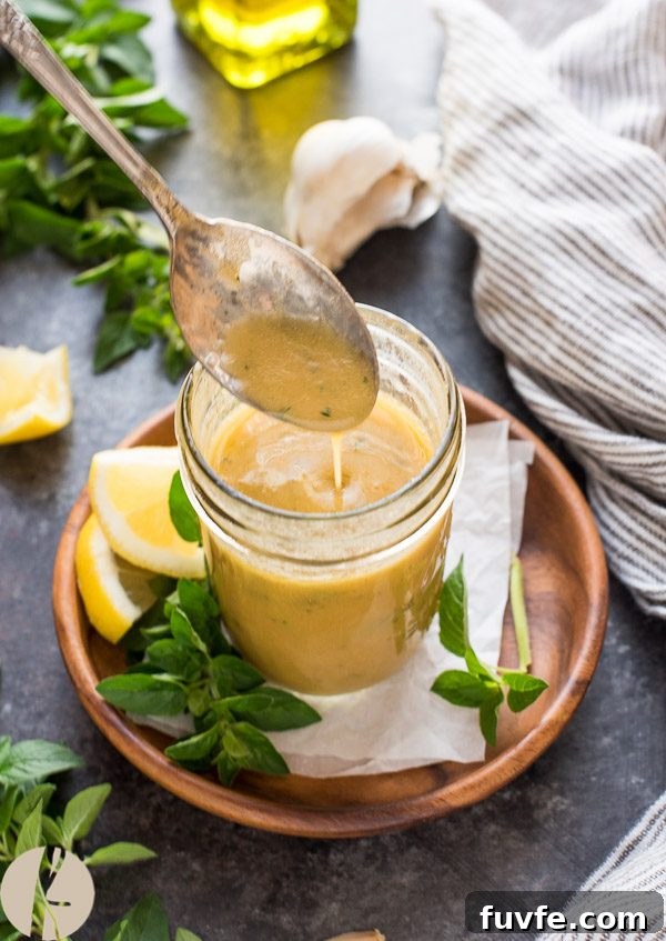 Greek dressing pouring from spoon