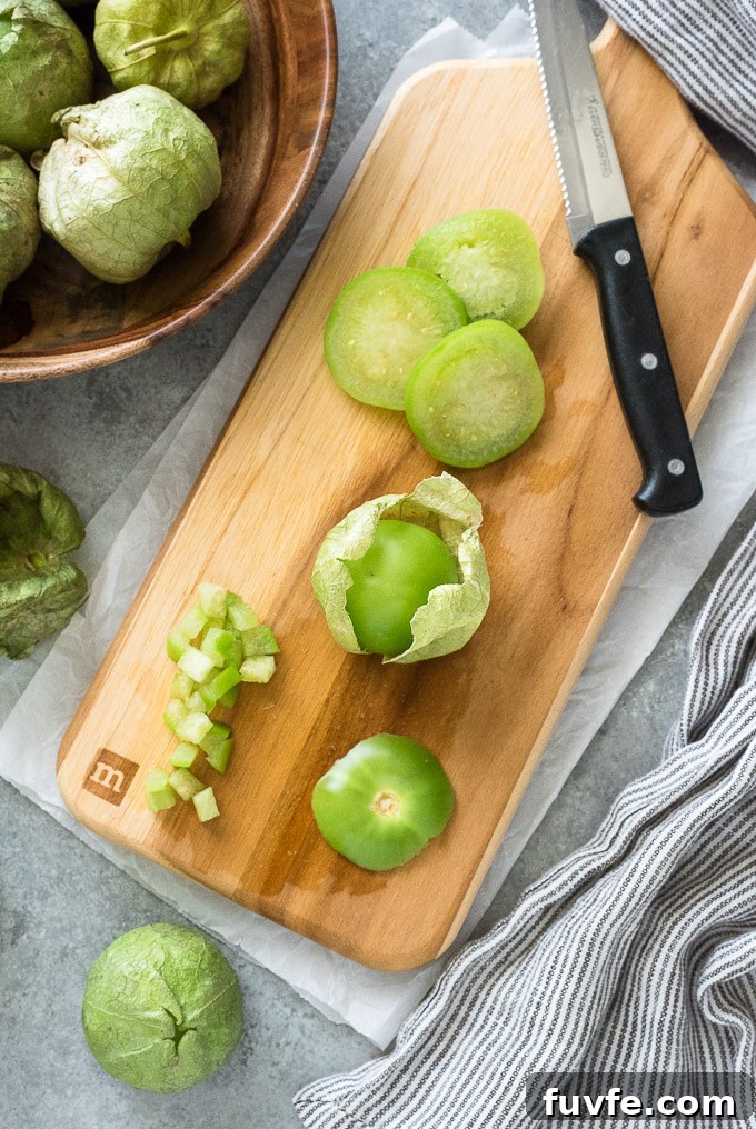 Diced, sliced and whole tomatillos on a cutting board
