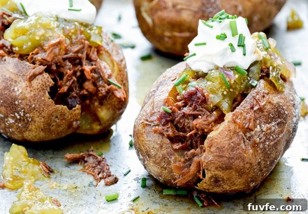 BBQ beef stuffed potatoes with sour cream and tomatillo salsa on top