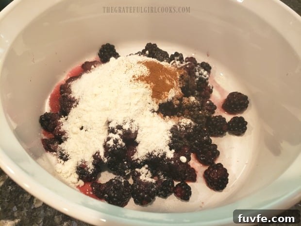 Blackberries, flour, cinnamon and sugar are combined in a medium sized bowl.