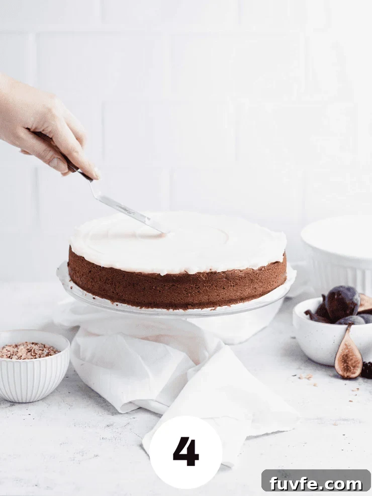 Norwegian Spice Cake Recipe: Classic Krydderkake with Warm Spices 8 Hand frosting the top of a single layer cake with white frosting.