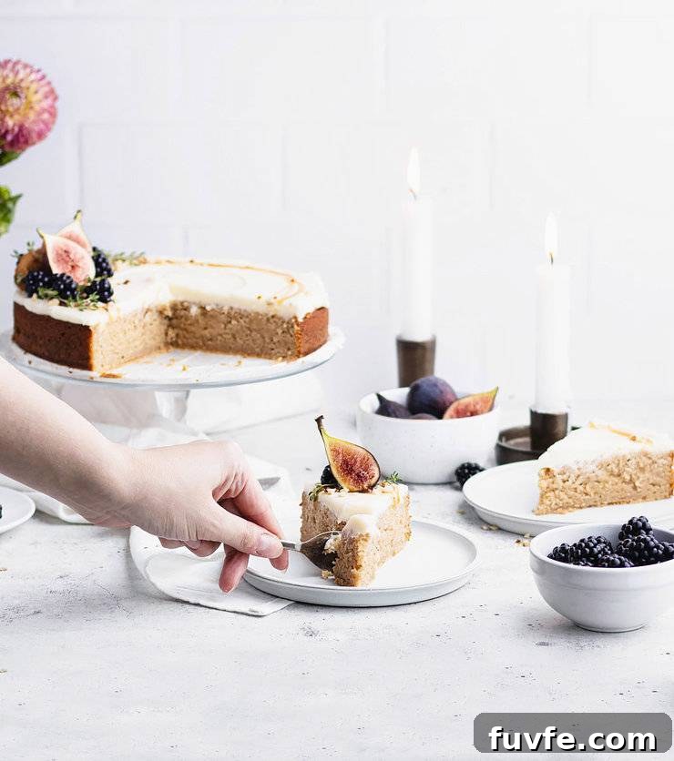 Norwegian Spice Cake Recipe: Classic Krydderkake with Warm Spices 10 Hand cutting into a plated slice of kyrdderkake with the larger cake, two lit taper candles and another slice slightly blurred in the background.