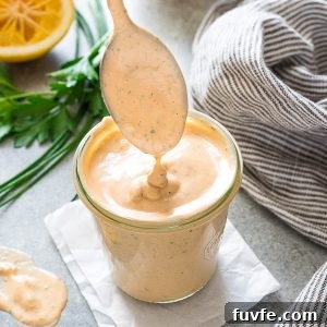 Louie salad dressing drizzling from spoon into jar