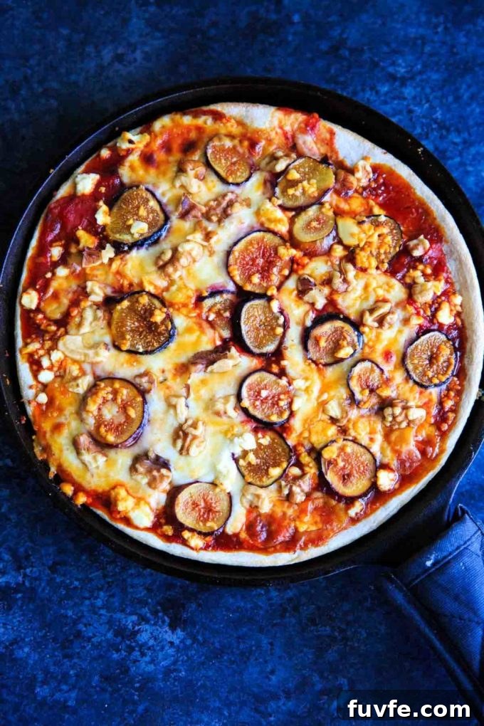 Overhead view of a honey fig pizza in a cast iron skillet.
