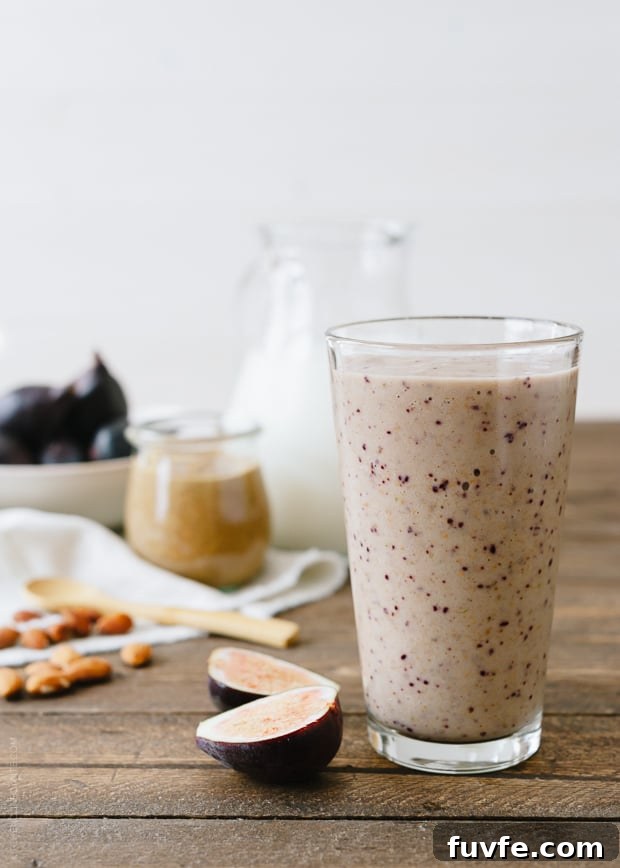 A fig and almond butter smoothie in a tall glass.