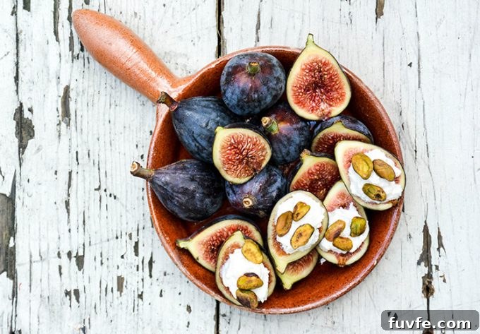 Overhead view of fresh figs with ricotta and pistachios in a dish.