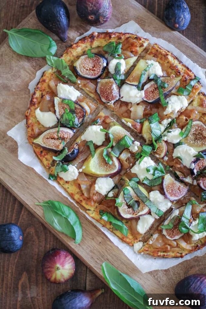 Overhead view of a sliced onion, fig, and ricotta pizza on a wooden board.