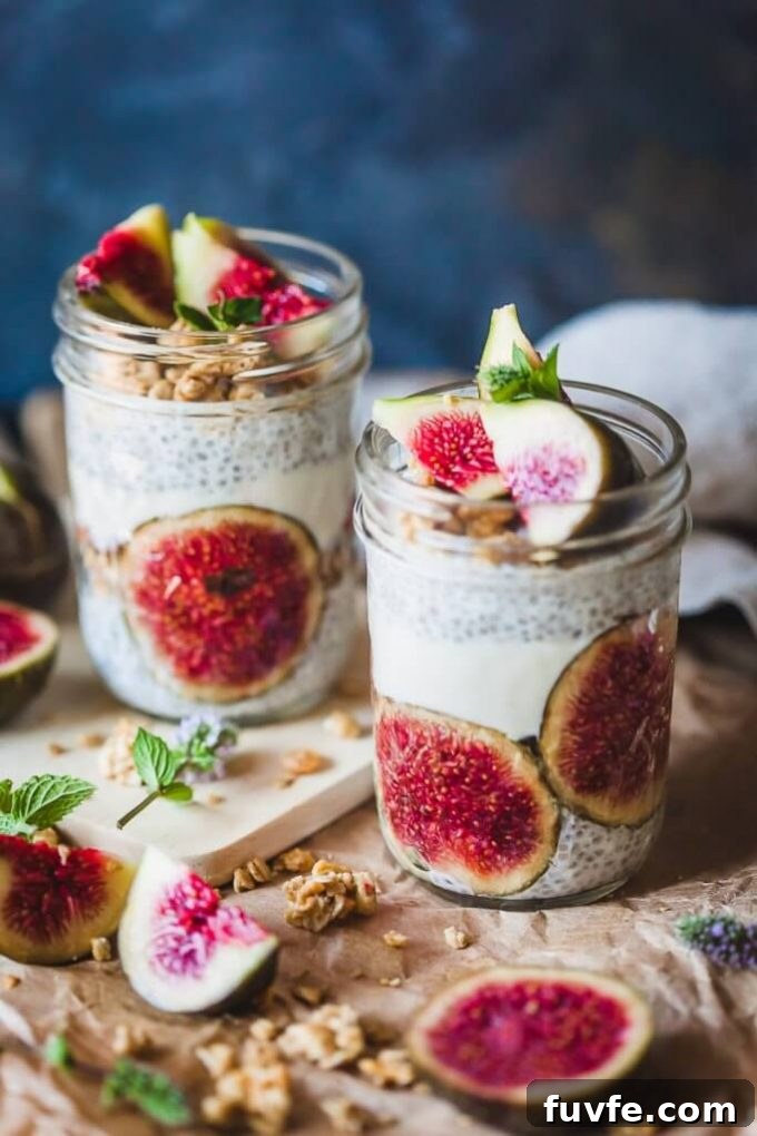 Two mason jars filled with fig chia pudding. Fig halves are scattered around them.