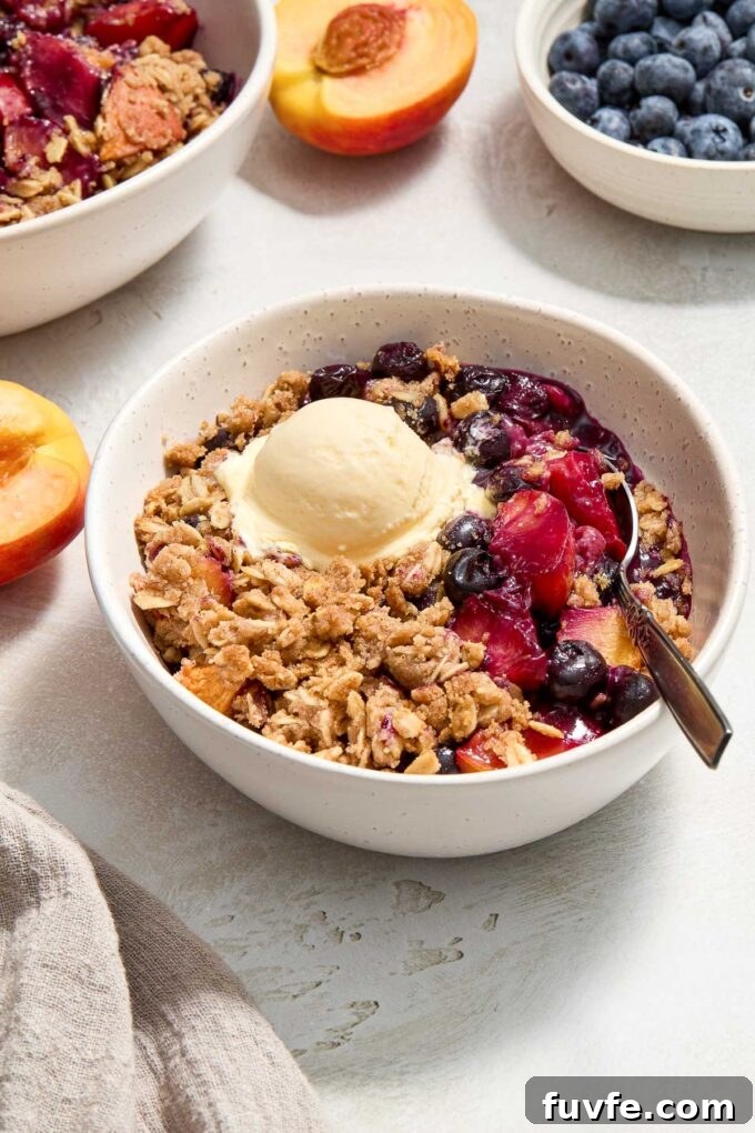 Peach and Blueberry Crisp Recipe with Oat Topping 7 Blueberry peach crisp in a bowl with ice cream on top.