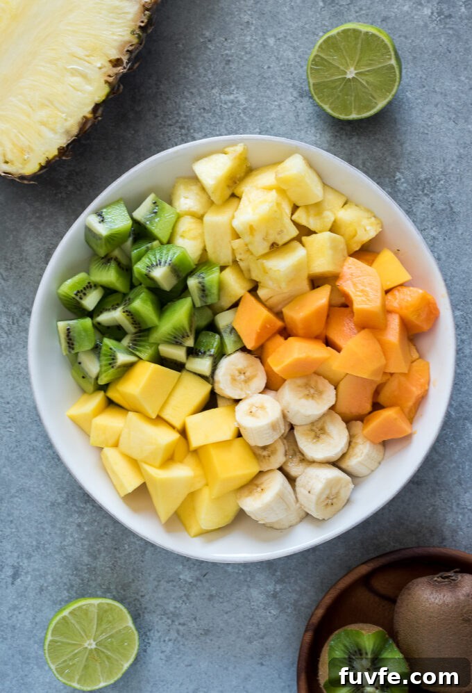 Refreshing Tropical Fruit Salad with Coconut and Lime 4 Tropical fruits in serving bowl before stirring.