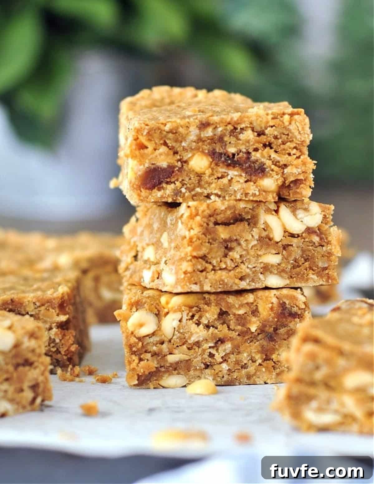 Vegan peanut butter bars on a cutting board, three squares stacked.