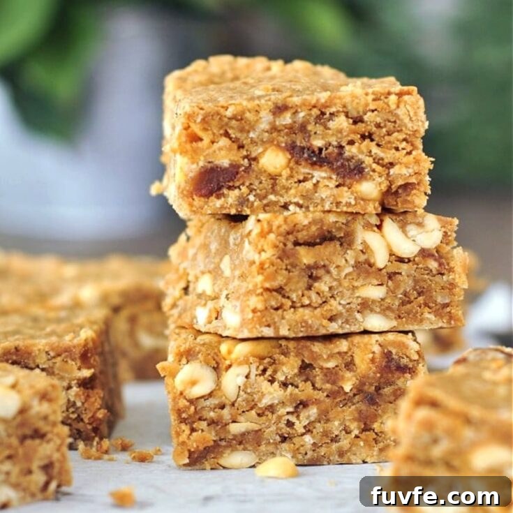 Vegan peanut butter bars on a cutting board, three squares stacked.