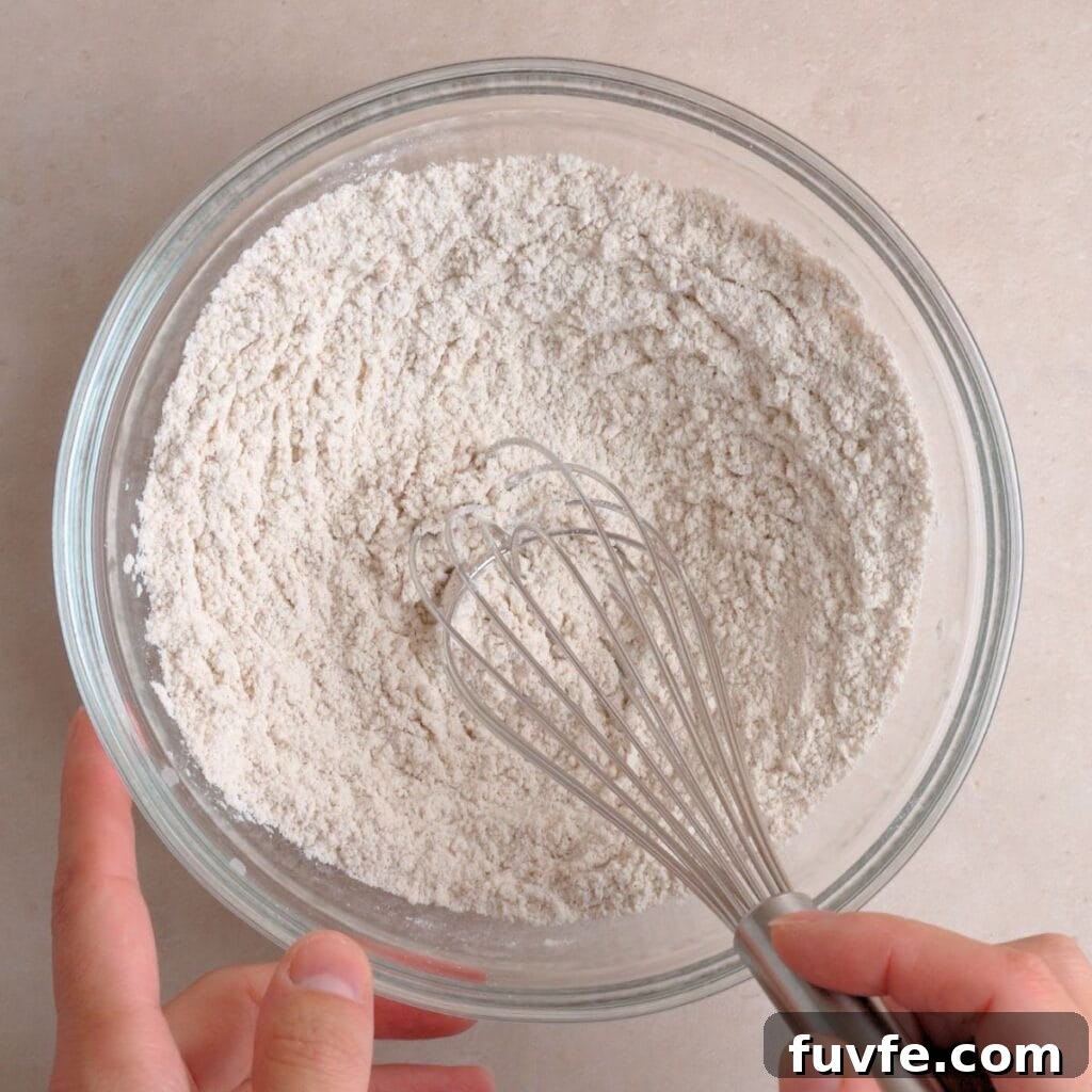 Flour, cinnamon, baking soda, and salt whisked together in a bowl.