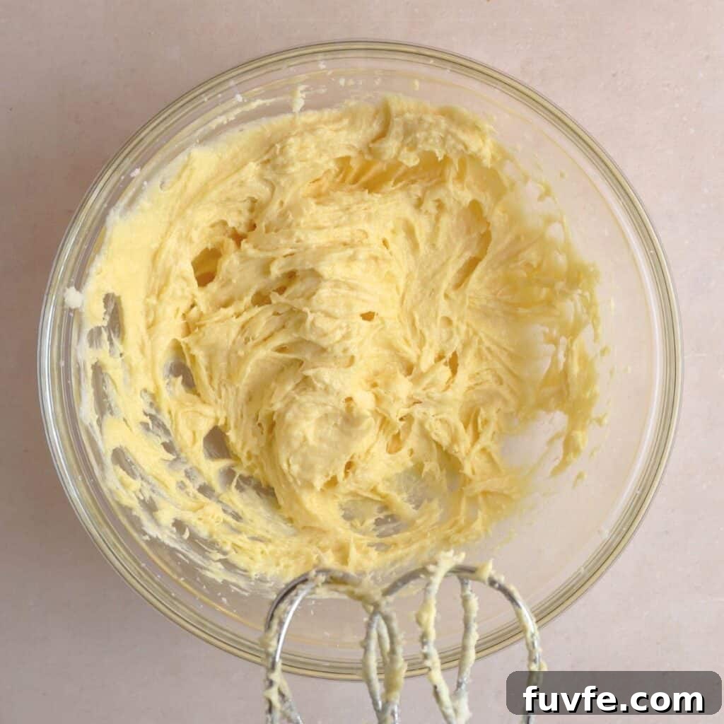Butter, sugar, sourdough discard, egg yolk, and vanilla extract creamed together in a bowl.