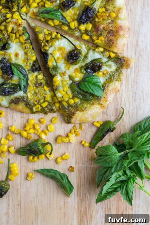 Overhead view of corn shishito pepper pizza sliced