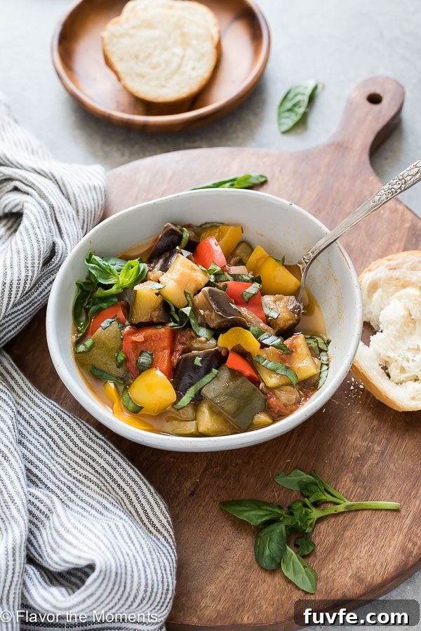 bowl of instant pot ratatouille with spoon in the bowl and bread alongside