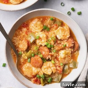 Instant Pot Jambalaya Soup in a bowl with a spoon topped with green onions