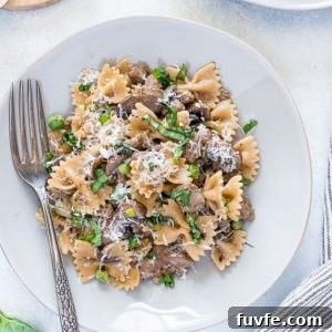 Sausage and bow tie pasta on a plate with a fork.
