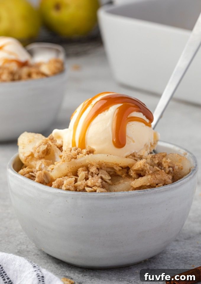 Warm Pear Crumble Recipe with Cinnamon Oat Topping 2 Pear crisp in a bowl with ice cream and caramel