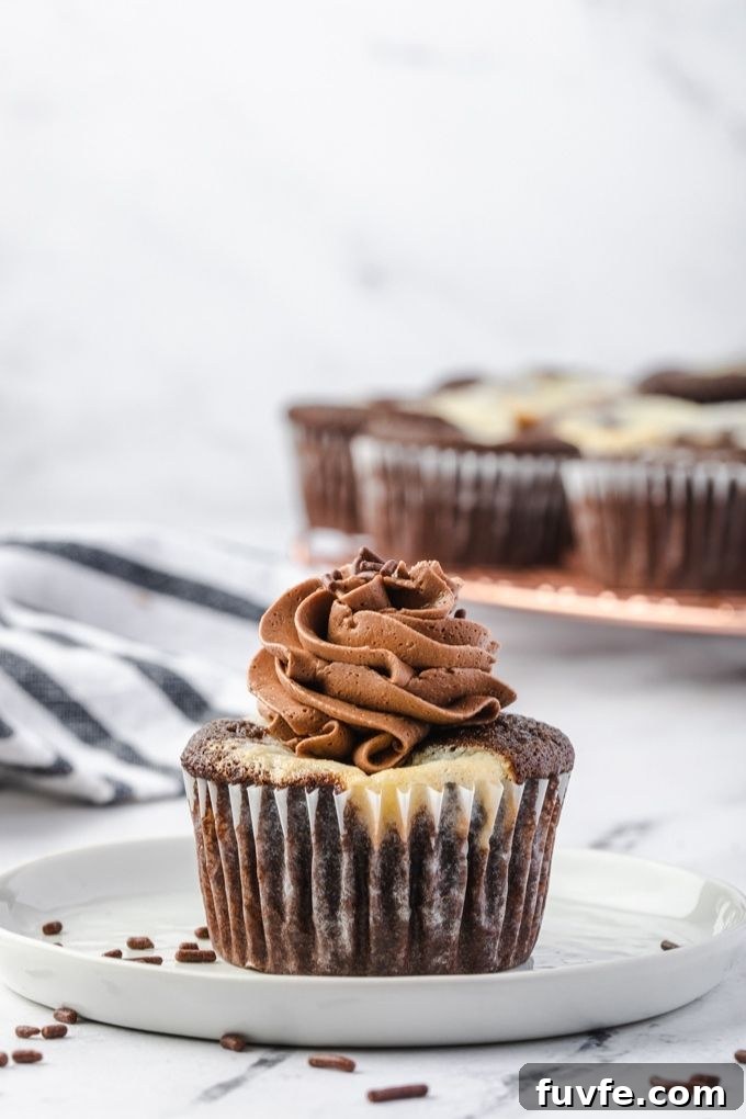 Black-Bottom Cupcakes with Salted Chocolate Buttercream 5 Black bottom cupcake with chocolate frosting on a plate
