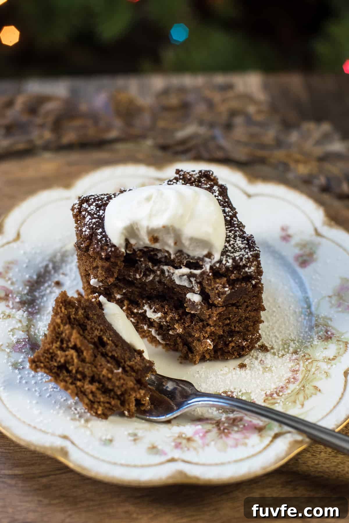 Warm Gingerbread Cake Recipe with Spiced Molasses Glaze 3 A fork resting on a plate after pulling away a bite of gingerbread cake.