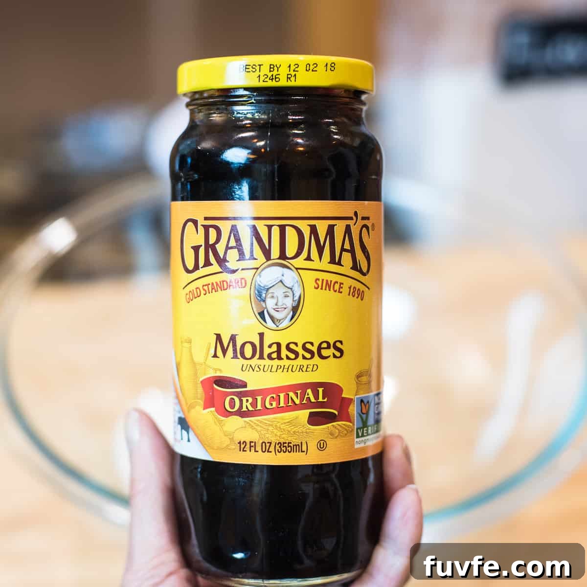 Warm Gingerbread Cake Recipe with Spiced Molasses Glaze 4 A hand holding a jar of Grandma's Molasses Unsulphured.