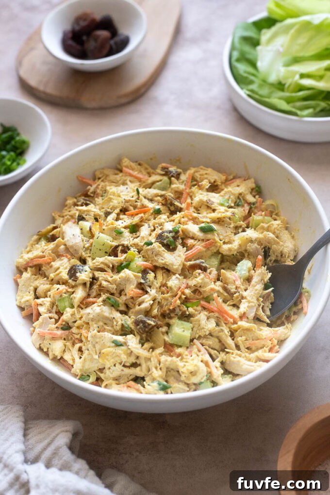 Creamy curry chicken salad with serving spoon digging in.