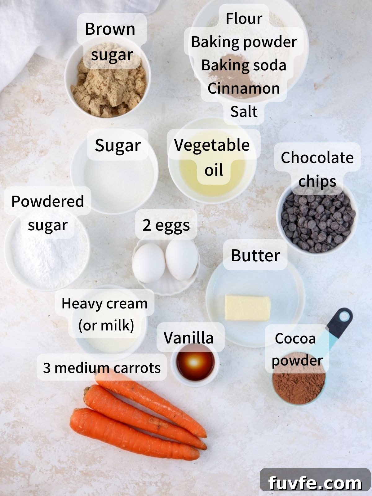 Labeled ingredients needed to make chocolate carrot cake laid out on a table.