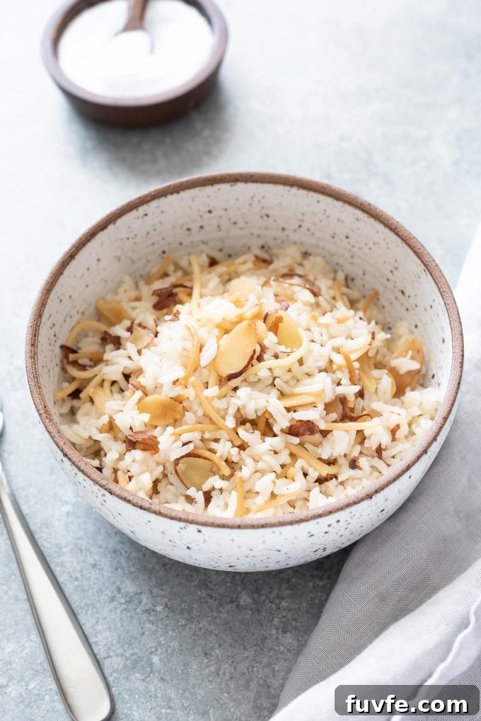 Fragrant Almond Rice Pilaf Recipe with Toasted Almonds 2 Bowl of almond rice pilaf with fork and linen