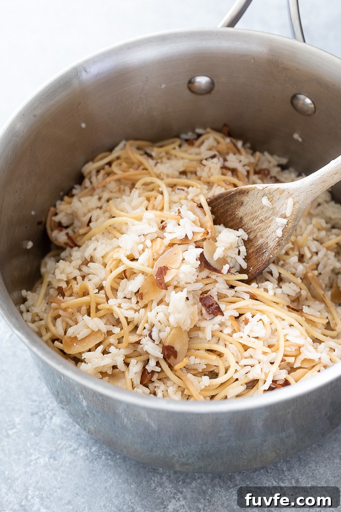 Fragrant Almond Rice Pilaf Recipe with Toasted Almonds 3 Wooden spoon in a pot of rice pilaf