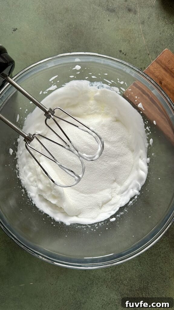 Combining the sugar to the egg white mixture.