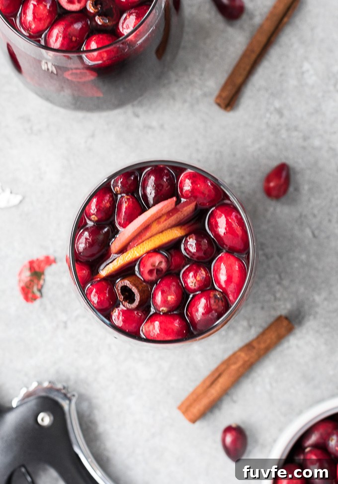 Cranberry Sangria Recipe for Holiday Parties 7 Glass of cranberry sangria with cinnamon sticks alongside