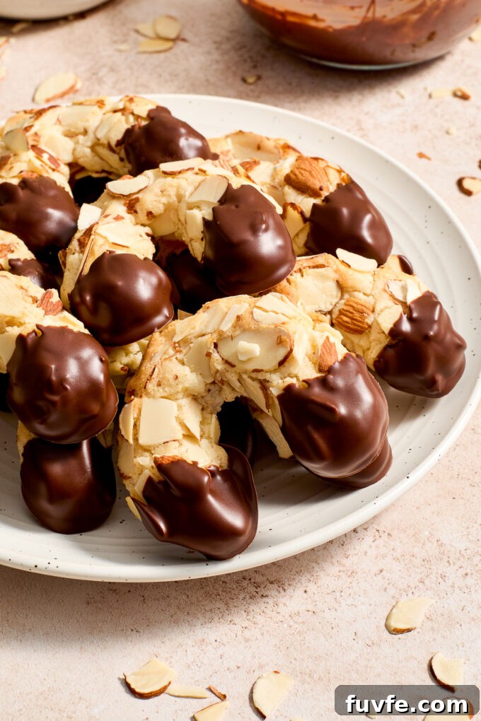 Chocolate-Dipped Almond Horn Cookies 3 Chocolate dipped almond horn cookies on a plate.