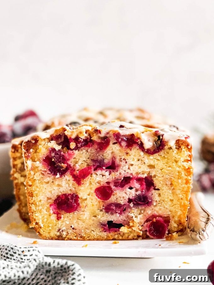 A sliced loaf of cranberry orange bread.