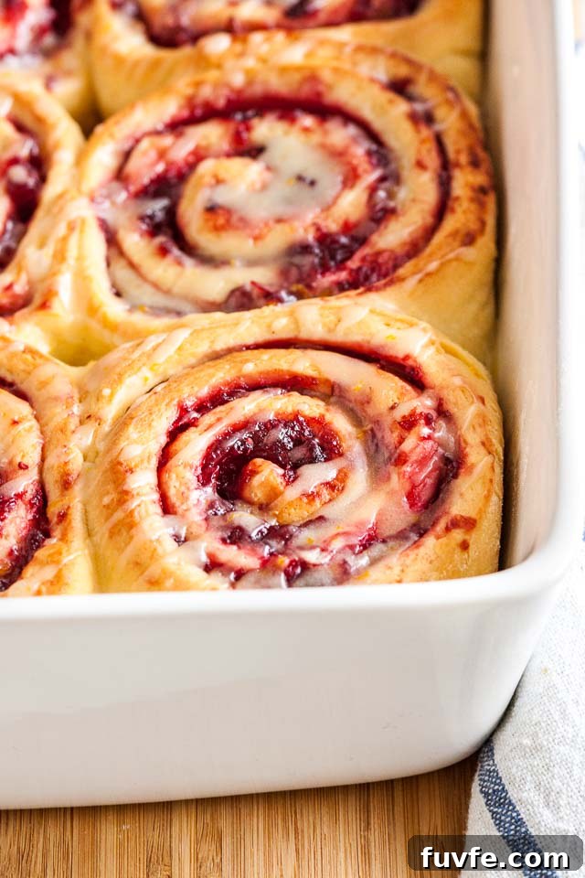 Cranberry orange rolls in a white baking dish.