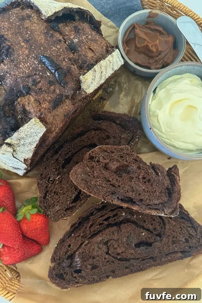 15 Irresistible Chocolate Sourdough Recipes to Try Today 12 A loaf of sourdough chocolate bread that has been sliced and laid out so you can see the rich interior. There is also some whipped cream and berries in the display.