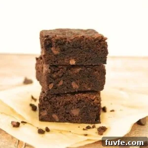 15 Irresistible Chocolate Sourdough Recipes to Try Today 30 A stack of 3 sourdough brownies showing the crispy top and fudgy inside. There are some sourdough brownie crumbs around the stack.