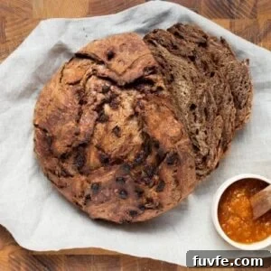 15 Irresistible Chocolate Sourdough Recipes to Try Today 34 A loaf of chocolate sourdough discard bread on a cutting board, sliced for serving with jam.