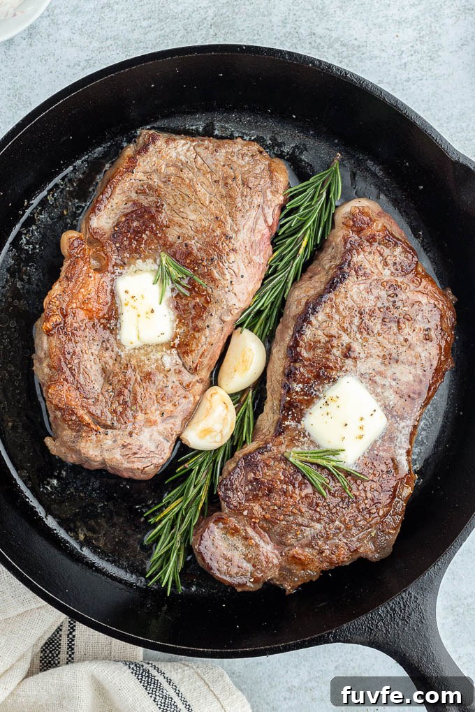 Pan-Seared Steak Recipe with Garlic Butter 3 Pan seared steaks in cast iron skillet with butter rosemary and garlic