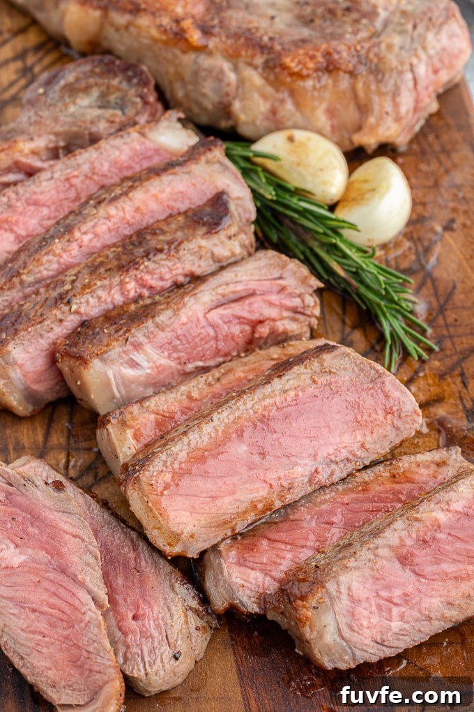 Pan-Seared Steak Recipe with Garlic Butter 8 Butter basted steak sliced on a cutting board