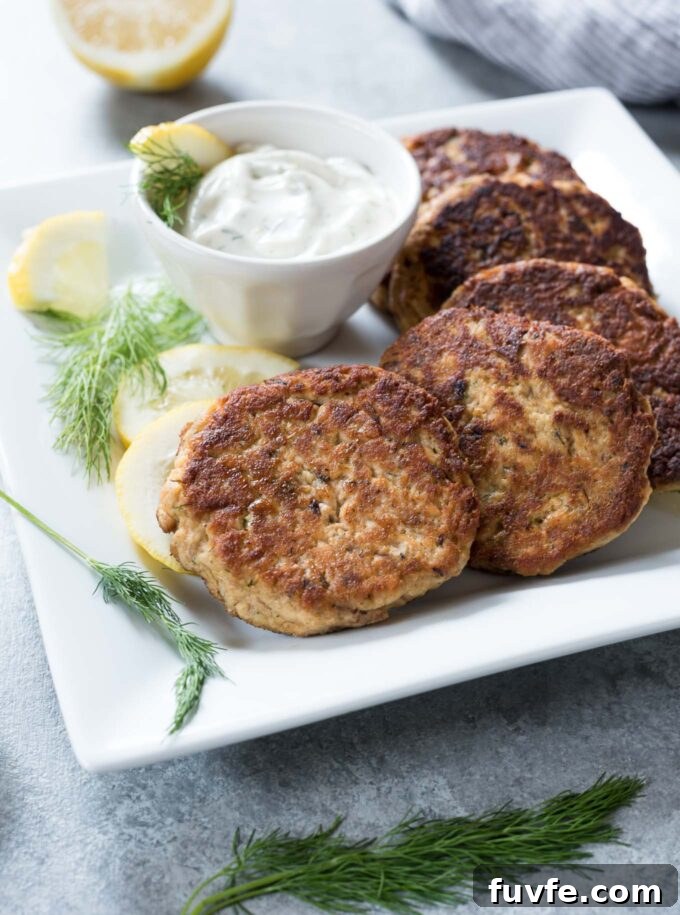 Salmon patties on a platter with lemon dill sauce